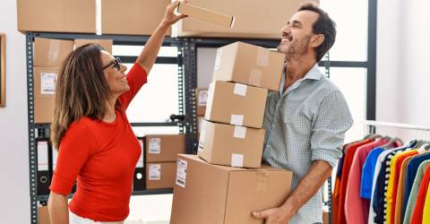 Een man en vrouw hard aan het werken om de pakketjes in te pakken om te verzenden